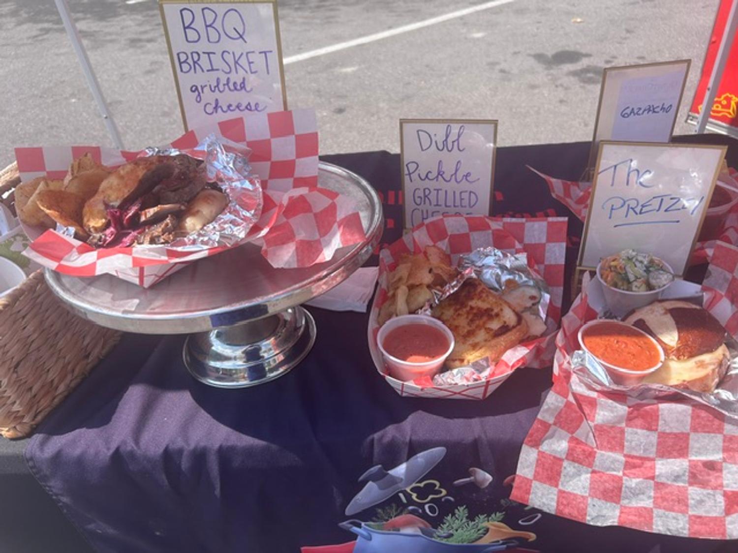 Event table featuring BBQ Brisket and Dill Pickle grilled cheese samples with gazpacho