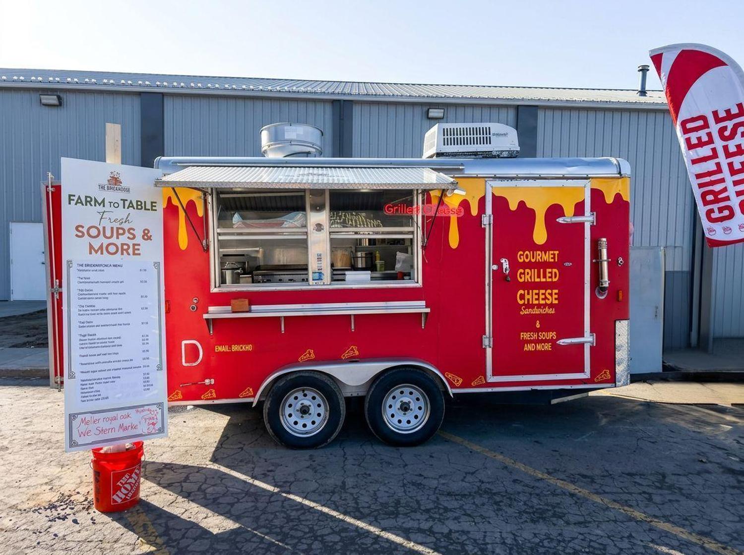 Our red gourmet grilled cheese trailer parked with the farm-to-table soups and more menu board