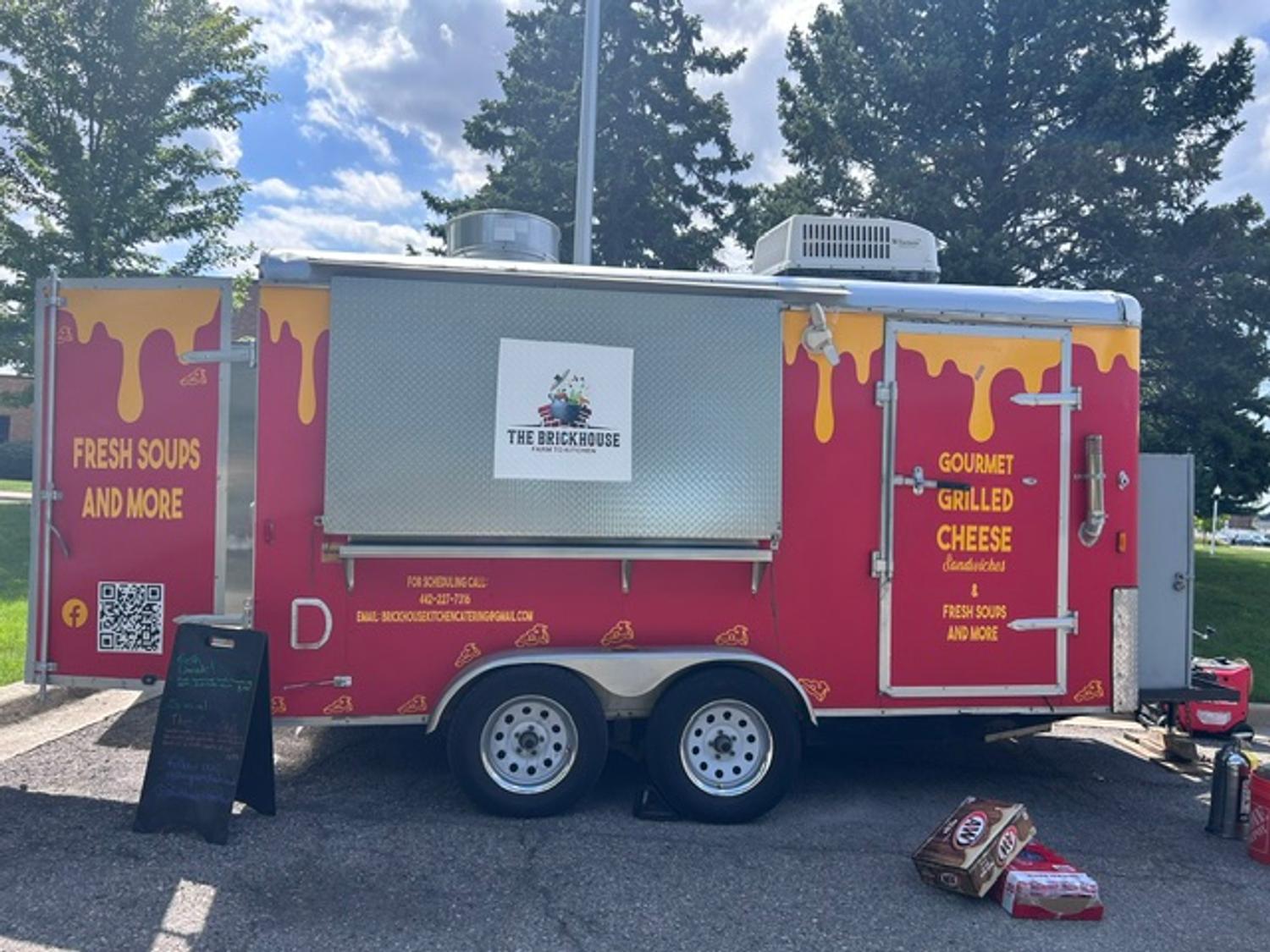 The Cheese Nerds trailer set up on a sunny day with the Brickhouse Kitchen logo