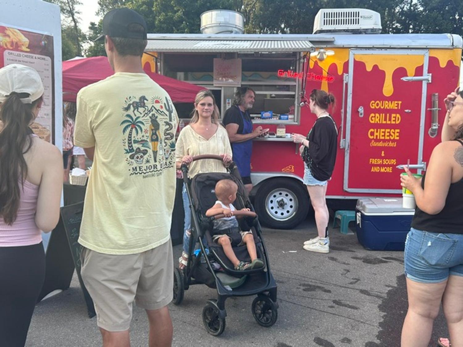 Guests lined up at the Cheese Nerds trailer during an evening festival